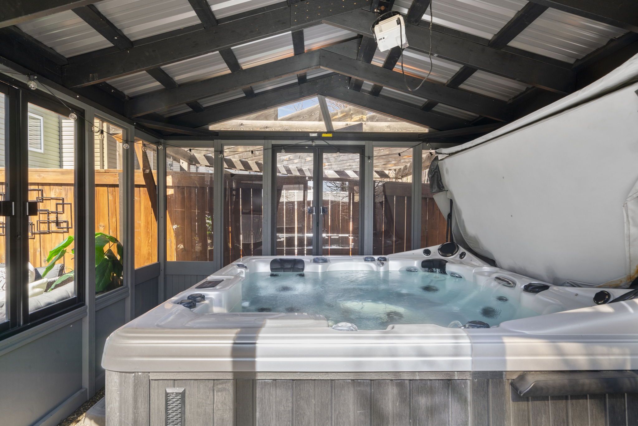 Covered hot tub in the landscaped backyard